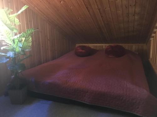 a bed in a room with a wooden ceiling at Ängsliden in Charlottenberg