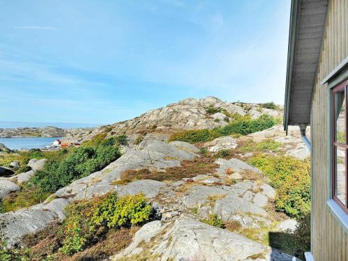a house on a rocky hill with a view of the ocean at 12 person holiday home in Sk rhamn in Skärhamn