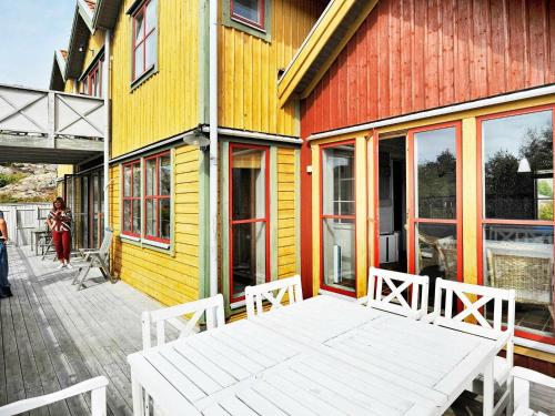 a white bench sitting outside of a colorful building at 12 person holiday home in Sk rhamn in Skärhamn