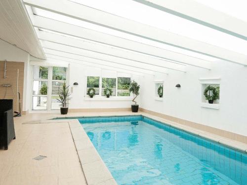 uma piscina numa casa com tecto branco em 12 person holiday home in Eg em Åstrup