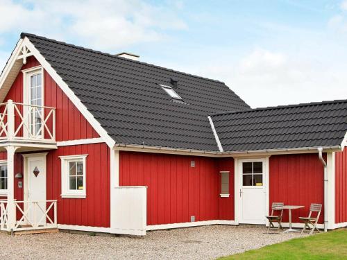 a red barn with a black roof at 8 person holiday home in Brenderup Fyn-By Traum in Bro