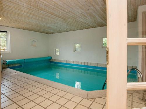 una gran piscina de agua azul en una habitación en 9 person holiday home in Bl vand, en Ho