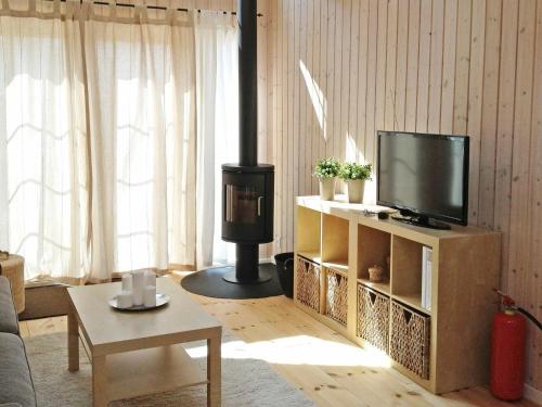 a living room with a tv and a wood stove at 4 person holiday home in Karreb ksminde in Karrebæksminde