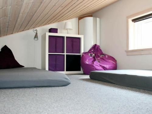 グドイェムにあるHoliday Home Rø Skolevej IIIのベッドルーム1室(紫色のクッションが置かれたベッド2台、窓付)