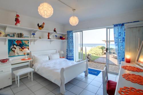 1 dormitorio con cama y vistas al océano en Wilderness Beach Cottage, en Wilderness
