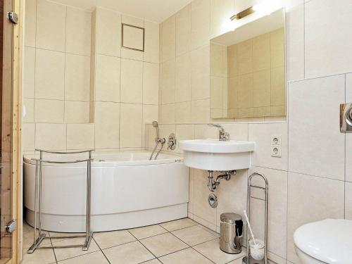 uma casa de banho com uma banheira, um lavatório e um WC. em Two-Bedroom Holiday home in Großenbrode 8 em Grossenbrode