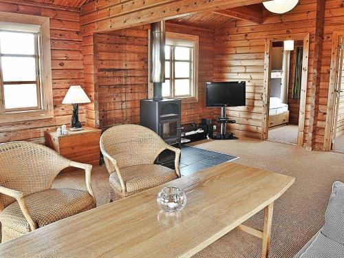 a living room with a table and chairs and a television at 6 person holiday home in Ringk bing in Søndervig