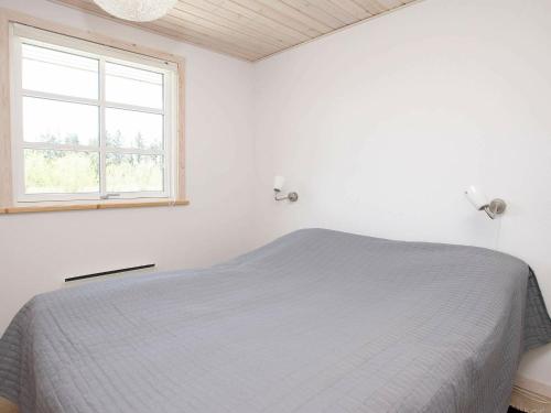 Three-Bedroom Holiday home in Brovst 31 في Brovst: غرفة نوم بيضاء بها سرير ونافذة