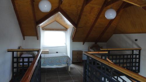 a attic room with a bed and a window at Cabañas Aires del Bosque in Concón