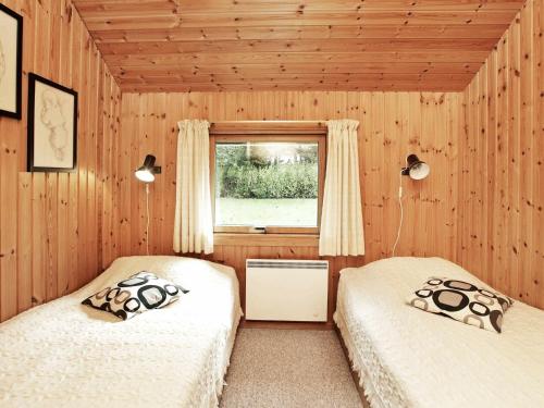 two twin beds in a room with a window at Three-Bedroom Holiday home in Idestrup 3 in Marielyst