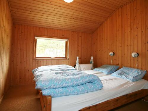 een slaapkamer met 2 bedden in een houten kamer bij Four-Bedroom Holiday home in Væggerløse 19 in Bøtø By