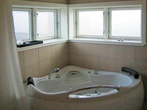 W łazience z 2 oknami znajduje się wanna. w obiekcie Three-Bedroom Holiday home in Broager 4 w mieście Broager
