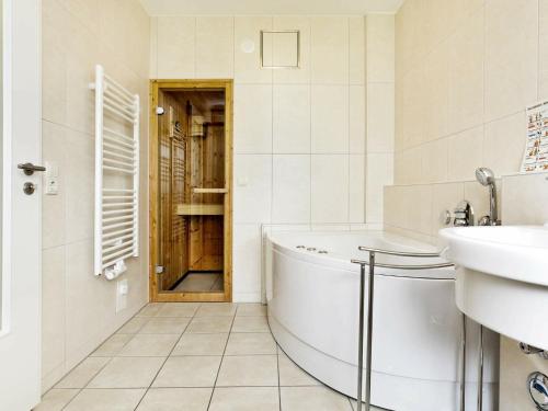 ein weißes Badezimmer mit einer Badewanne und einem Waschbecken in der Unterkunft One-Bedroom Holiday home in Großenbrode 2 in Großenbrode