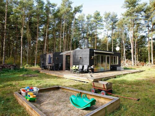 una casita negra en medio de un campo en 6 person holiday home in Hadsund, en Odde
