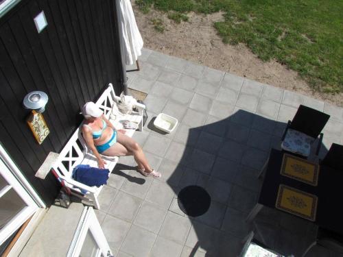 a woman sitting in a chair on a patio at 6 person holiday home in Skagen in Hulsig
