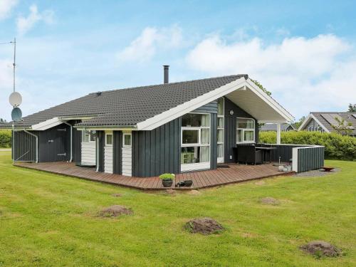 a house with a deck and a yard at 6 person holiday home in Hadsund in Øster Hurup