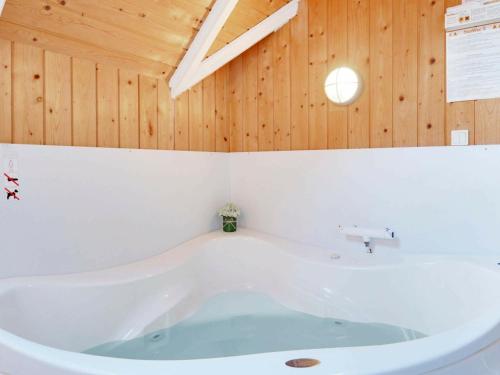 bañera en una habitación con techo de madera en 8 person holiday home in Bl vand en Blåvand