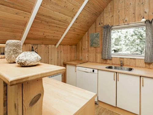 una cocina con armarios blancos y un lavabo en una cabaña en 8 person holiday home in Bl vand en Blåvand