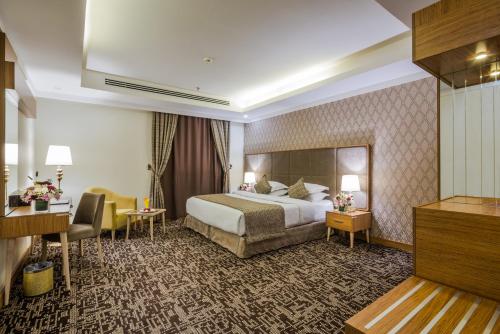 una camera d'albergo con un letto e una scrivania di Le Park Concord Hotel Al Majmaah a Al Majmaah