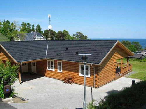 una casa di tronchi con un ampio patio di fronte di 6 person holiday home in Allinge ad Allinge