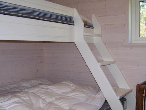 ApelgårdenにあるOne-Bedroom Holiday home in Kållekärrの白い二段ベッド(はしご付)が備わる客室です。