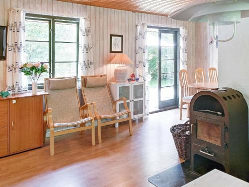 een woonkamer met een houtkachel en een tafel bij 6 person holiday home in Nex in Snogebæk