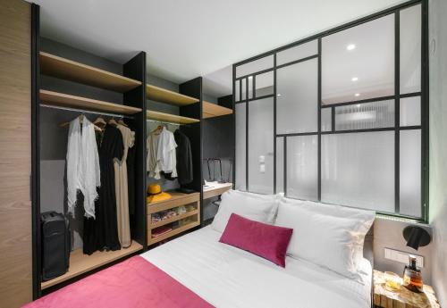 - une chambre avec un lit blanc et un oreiller rose dans l'établissement Olvios Luxury Suites, à Thessalonique