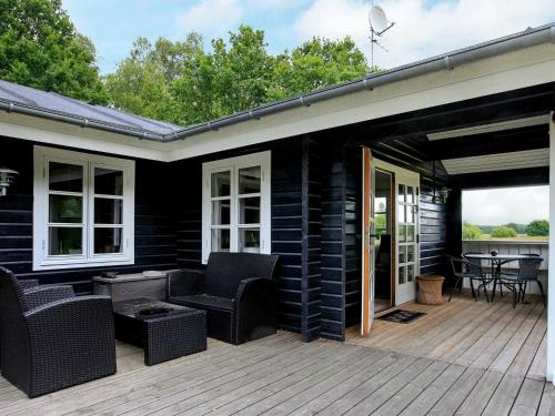 a patio with wicker furniture on a wooden deck at 6 person holiday home in L s in Læsø