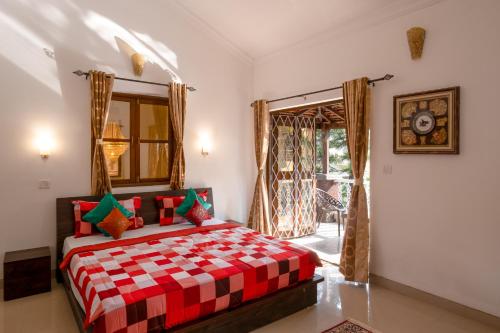 um quarto com uma cama xadrez vermelha e branca em West Valley Villa ,North Goa em Old Goa