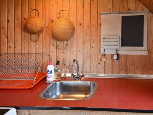 a kitchen sink with two hanging baskets on the wall at Holiday home Hvide Sande VIII in Havrvig