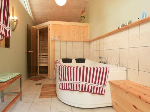 uma banheira numa cozinha com uma toalha vermelha e branca em Three-Bedroom Holiday home in Græsted 4 em Udsholt Sand