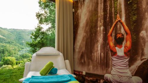 a woman doing a yoga pose in front of a window at Agrinho Suites & Spa Gerês in Valdosende
