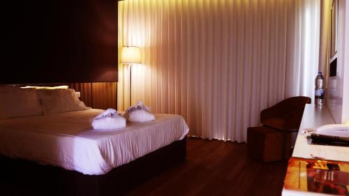 a hotel room with a bed with two towels on it at Agrinho Suites & Spa Gerês in Valdosende