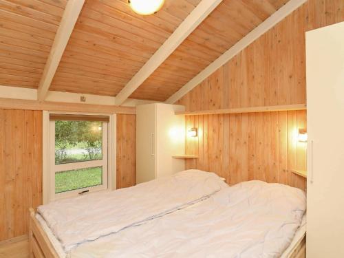 ÅlbækにあるHoliday home Ålbæk XIIの木製の壁と大型ベッドが備わるベッドルーム1室が備わります。