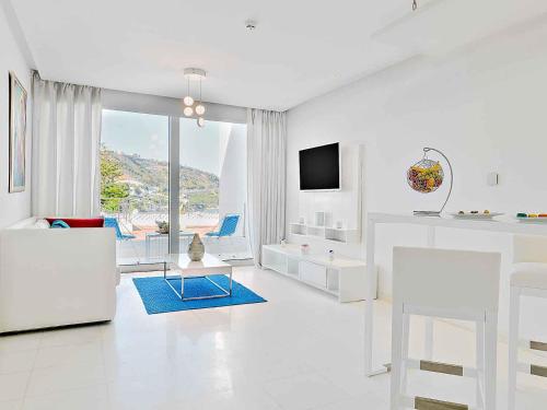 a living room with white furniture and a large window at La Tour Blanche in Gammarth