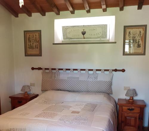 a bedroom with a bed and two night stands and a window at La Casa nel Chianti in Greve in Chianti