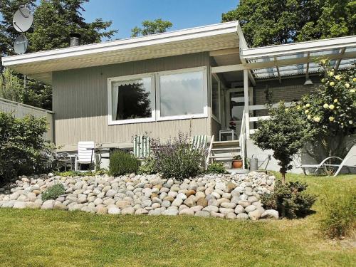 a house with a pile of rocks in front of it at 6 person holiday home in Nyk bing Sj in Højby