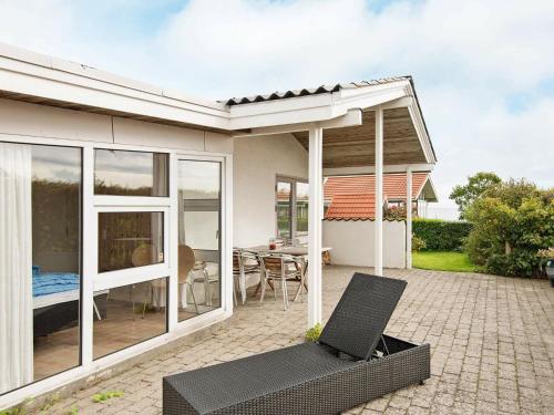 ein Haus mit einer Terrasse mit einem Tisch und Stühlen in der Unterkunft 6 person holiday home in Malling in Malling