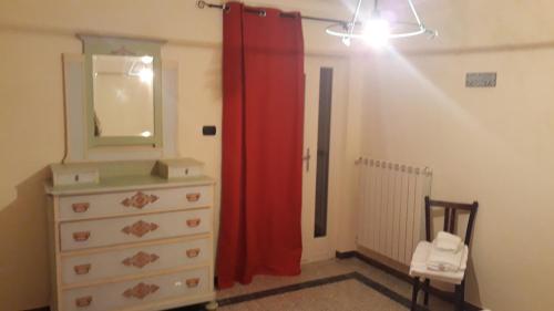 a bedroom with a dresser and a red curtain at Agriturismo Cascina Binelli in Dogliani