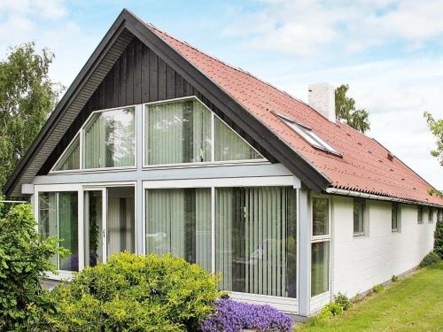 een huis met een rood dak en ramen bij 4 person holiday home in K ge in Strøby Egede