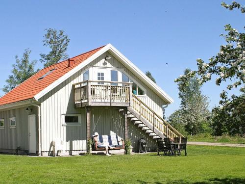 une grande grange blanche avec une terrasse couverte et une terrasse. dans l'établissement 4 person holiday home in Romelanda, à Romelanda