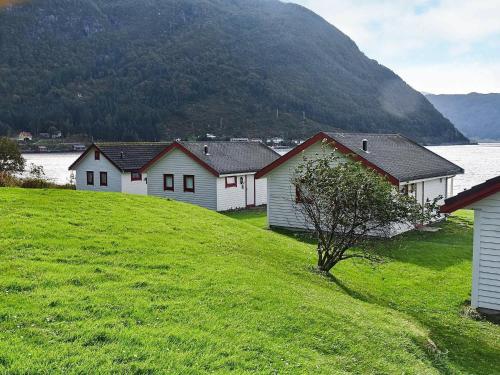 uma fila de casas numa colina ao lado de uma massa de água em 5 person holiday home in Selje em Selje