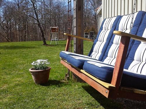 a bench sitting in a yard with a potted plant at 4 person holiday home in Romelanda in Romelanda