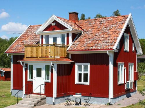 una casa roja con una terraza encima en 5 person holiday home in S DER KRA, en Söderåkra