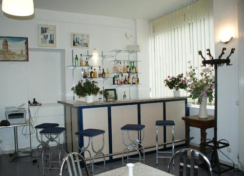 
a room with a table, chairs, and a clock on the wall at Hotel Garni Aaberna in Berlin
