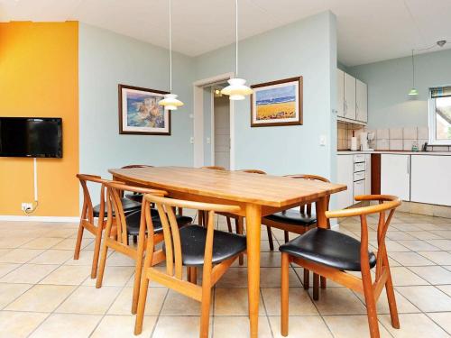 a kitchen and dining room with a wooden table and chairs at 8 person holiday home in Bl vand in Blåvand