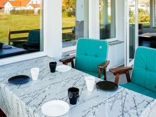 ファルケンベリにある8 person holiday home in GLOMMENのポーチにテーブルと椅子