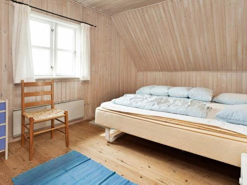 - une chambre avec un grand lit et une chaise dans l'établissement Holiday Home Horns Rev III, à Blåvand