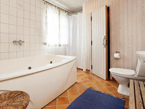 La salle de bains est pourvue d'une baignoire, de toilettes et d'un lavabo. dans l'établissement Holiday Home Horns Rev III, à Blåvand