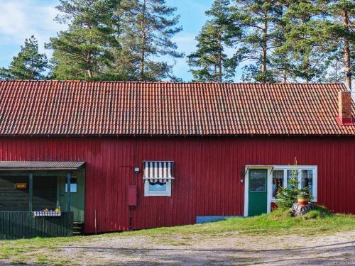 eine rote Scheune mit rotem Dach in der Unterkunft 5 person holiday home in Fengersfors in Fengersfors